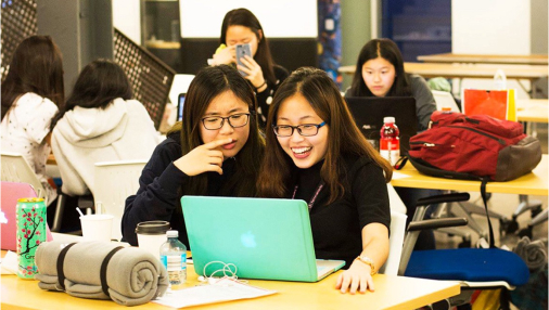 Two students working on a laptop.